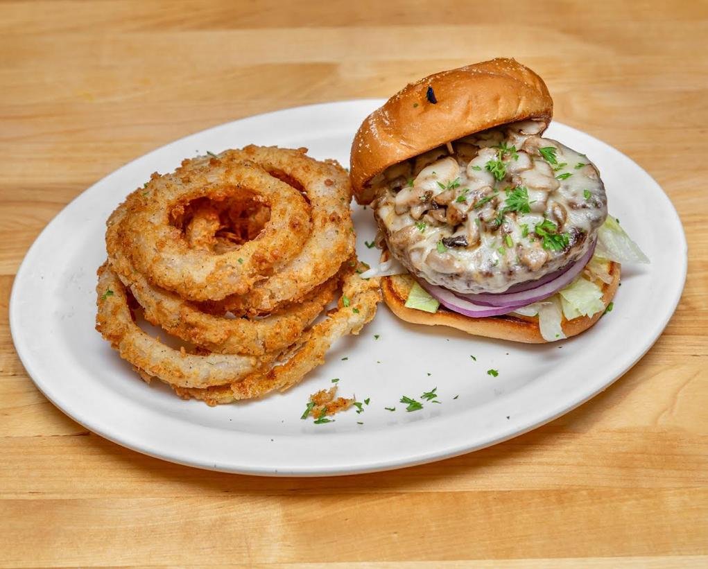 Mushroom and Swiss burger served with crispy onion rings